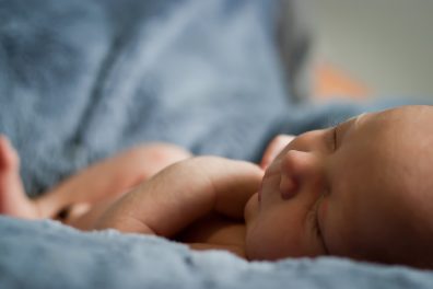 babaöltöztetés, kisbaba alszik az ágyban, kép.