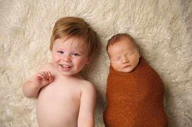 Mikor jöjjön a kistestvér, a képen bal oldalon egy 2 éves kisfiú, aki mosolyog, mellette jobb oldalon pedig egy újszülött kisbaba látható, aki alszik, kép.