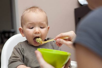 1 éves étrendje, fiú kisgyermeket etet péppel az anyukája, kanállal egy kis tálból, kép.
