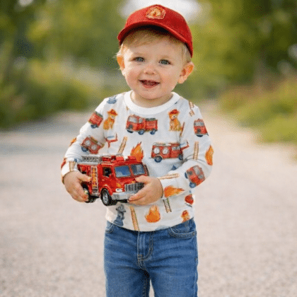 Baba felső tűzoltó autós mintával, aranyos és kényelmes babaruha, egy mosolygós kisfiún, akinek tűzoltó autó van a kezében.